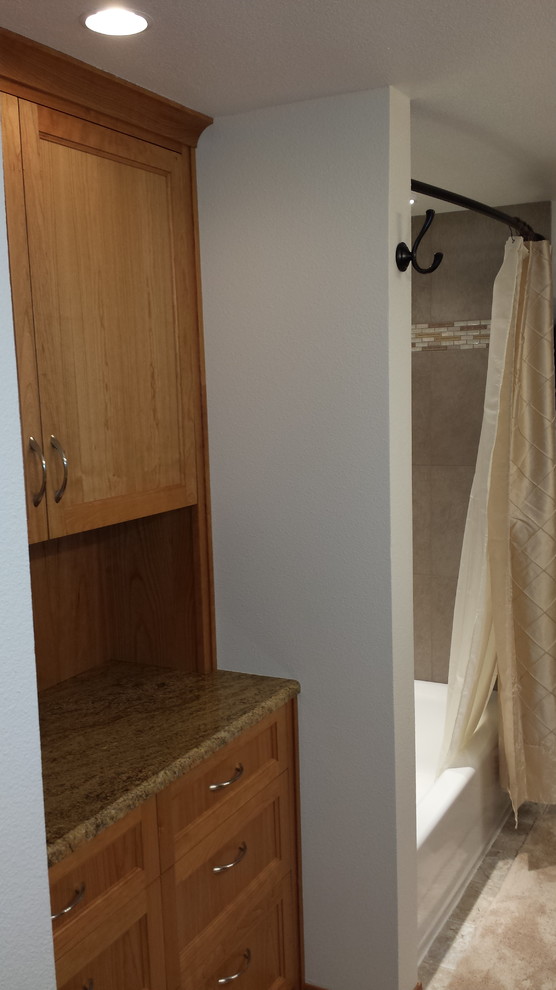 Foto de cuarto de baño clásico de tamaño medio con armarios con rebordes decorativos, puertas de armario de madera clara, paredes blancas, suelo de baldosas de porcelana, aseo y ducha, lavabo bajoencimera y encimera de granito