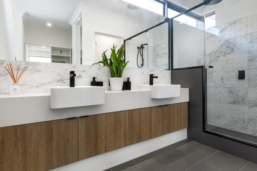 Modern inredning av ett stort vit vitt en-suite badrum, med släta luckor, beige skåp, en dusch i en alkov, grå kakel, porslinskakel, klinkergolv i porslin, ett fristående handfat, grått golv och dusch med gångjärnsdörr