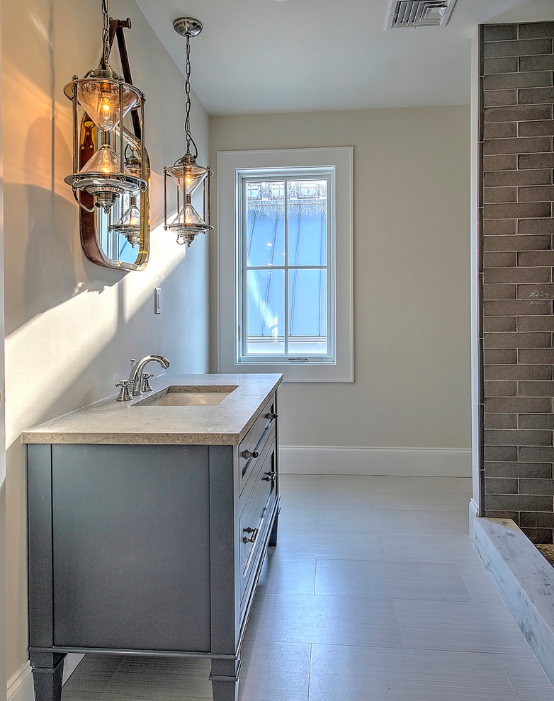 This is an example of a medium sized farmhouse family bathroom in New York with freestanding cabinets, grey cabinets, an alcove shower, a two-piece toilet, grey tiles, ceramic tiles, beige walls, porcelain flooring, a submerged sink and limestone worktops.