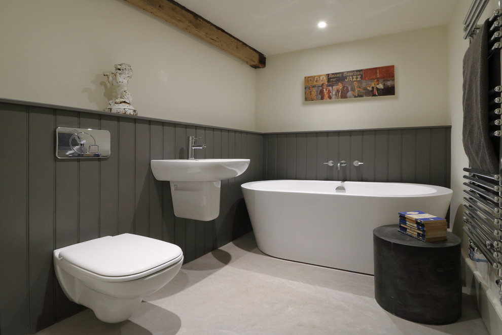Стильный дизайн: маленькая ванная комната в современном стиле с отдельно стоящей ванной, инсталляцией, бежевыми стенами, бетонным полом и подвесной раковиной для на участке и в саду - последний тренд