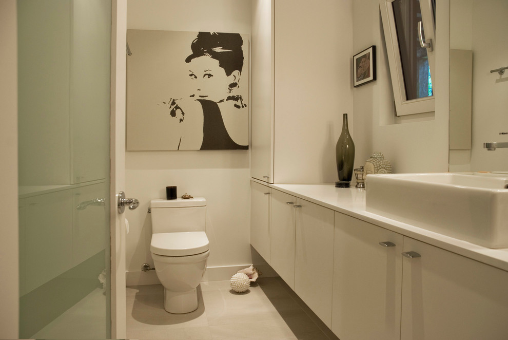 Contemporary bathroom in Vancouver with a vessel sink, flat-panel cabinets, beige cabinets, beige tiles, beige walls and white worktops.