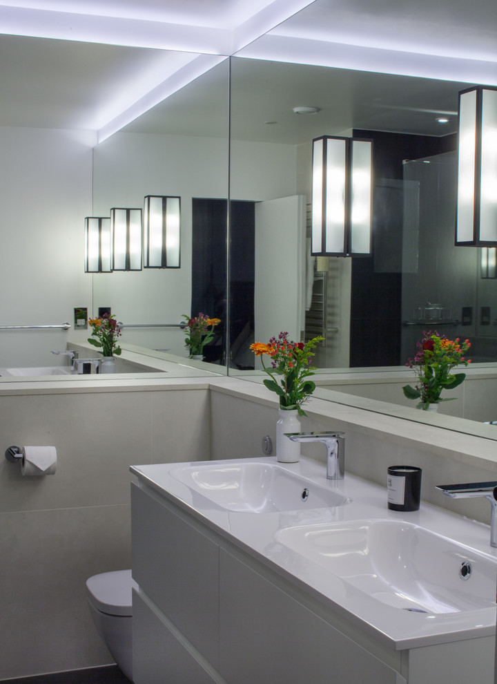 Esempio di una stanza da bagno padronale design di medie dimensioni con lavabo integrato, ante bianche, top in superficie solida, WC sospeso, piastrelle in ceramica e pavimento con piastrelle in ceramica