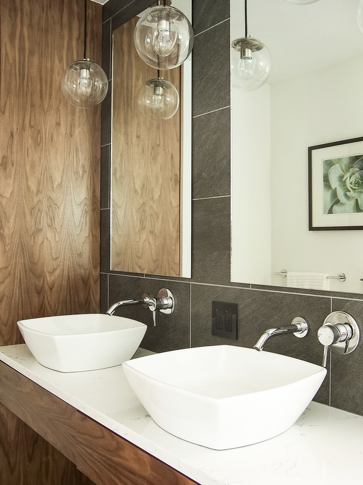 Photo of a medium sized modern ensuite bathroom in Grand Rapids with grey tiles, quartz worktops, flat-panel cabinets, medium wood cabinets, ceramic tiles, a vessel sink and brown walls.
