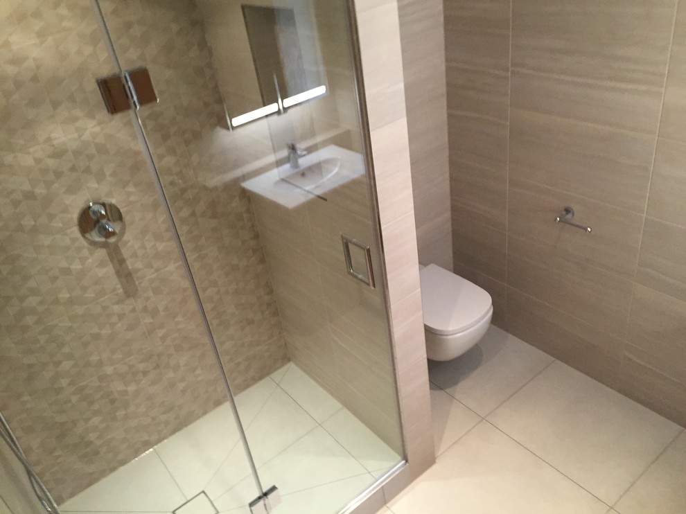 Cette image montre une salle de bain principale design de taille moyenne avec WC suspendus, un carrelage beige, des carreaux de porcelaine, un mur beige et un sol en carrelage de porcelaine.