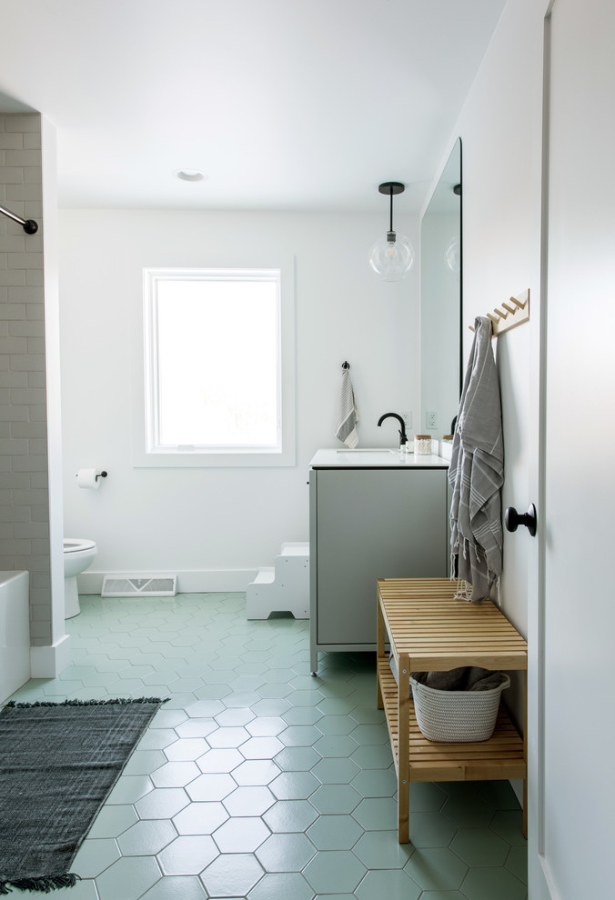 На фото: большая детская ванная комната в скандинавском стиле с плоскими фасадами, белыми фасадами, ванной в нише, открытым душем, бежевой плиткой, керамической плиткой, белыми стенами, полом из керамической плитки, врезной раковиной, столешницей из кварцита, зеленым полом, шторкой для ванной и белой столешницей