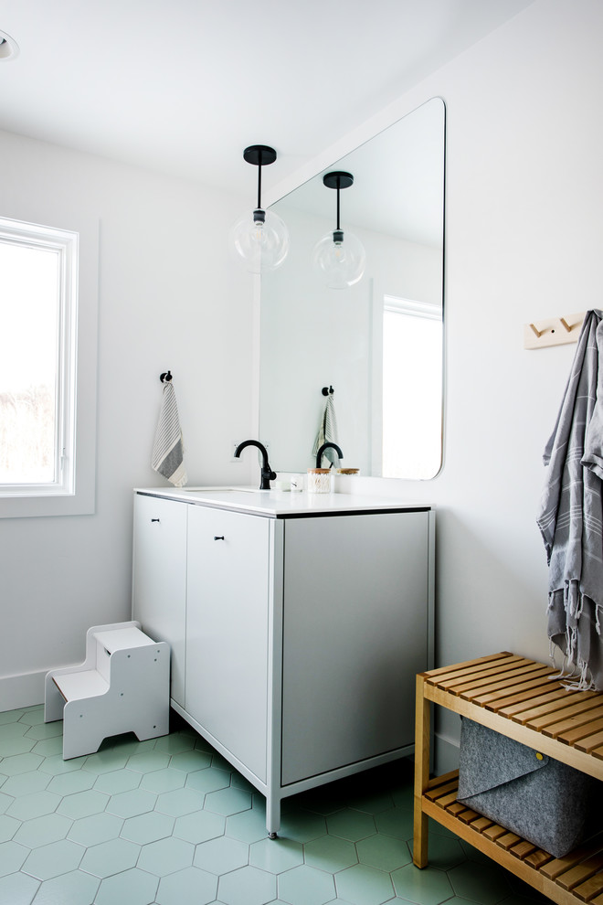 Inredning av ett nordiskt stort vit vitt badrum för barn, med släta luckor, vita skåp, vita väggar, klinkergolv i keramik, ett undermonterad handfat, bänkskiva i kvartsit och grönt golv