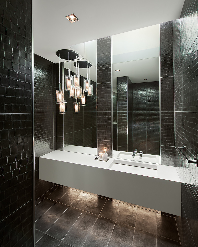 Foto de cuarto de baño actual con lavabo integrado y baldosas y/o azulejos negros