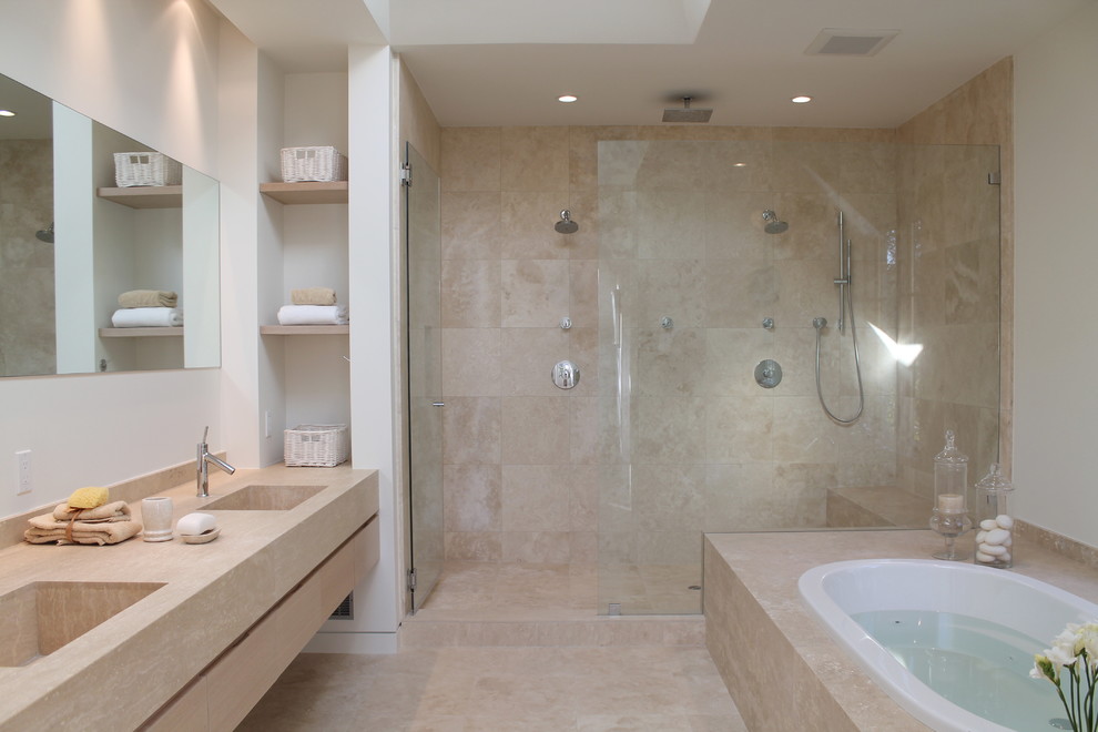 Immagine di una grande stanza da bagno padronale mediterranea con lavabo integrato, ante in legno chiaro, vasca da incasso, piastrelle beige, piastrelle in pietra, WC monopezzo, ante lisce, pareti bianche e pavimento in travertino