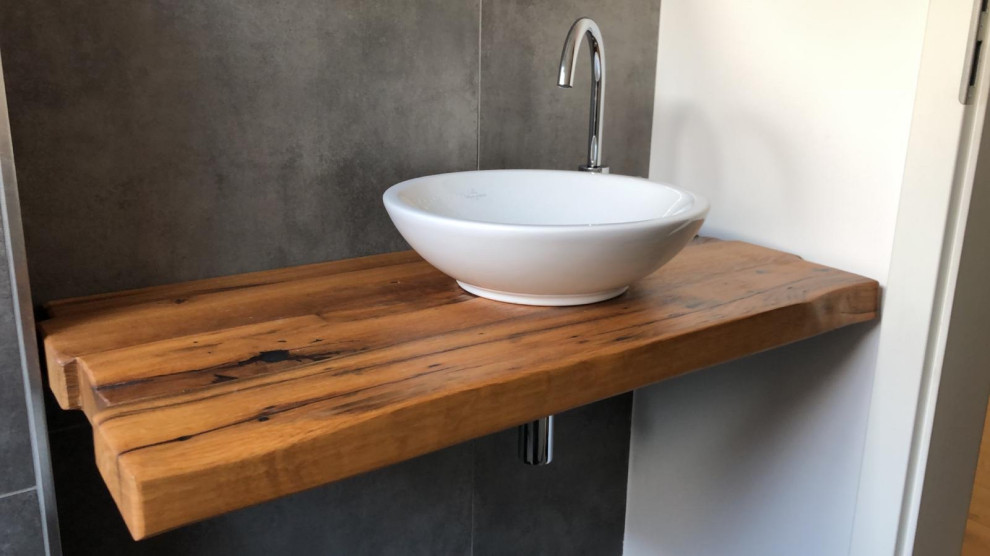 Immagine di una piccola stanza da bagno contemporanea con piastrelle grigie, pareti grigie, lavabo a bacinella, top in legno, top marrone, un lavabo e mobile bagno sospeso