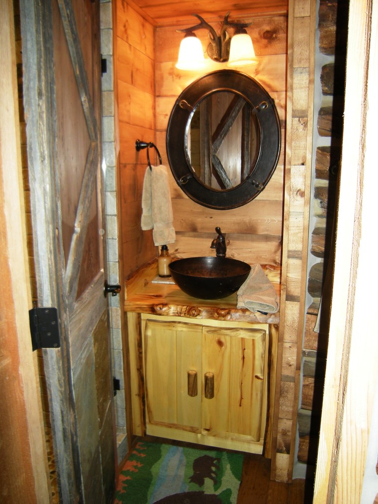 Inspiration för små rustika badrum med dusch, med släta luckor, skåp i ljust trä, en toalettstol med separat cisternkåpa, bruna väggar, mellanmörkt trägolv, ett fristående handfat och träbänkskiva