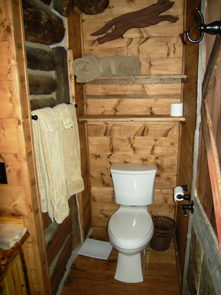 Example of a small mountain style 3/4 medium tone wood floor bathroom design in Denver with a two-piece toilet, brown walls, a vessel sink, flat-panel cabinets, light wood cabinets and wood countertops