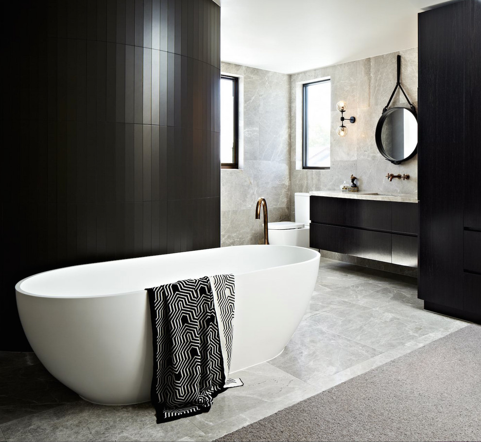 Modern inredning av ett grå grått en-suite badrum, med släta luckor, grå skåp, ett fristående badkar, våtrum, en toalettstol med separat cisternkåpa, grå kakel, marmorkakel, grå väggar, marmorgolv, marmorbänkskiva, grått golv och med dusch som är öppen