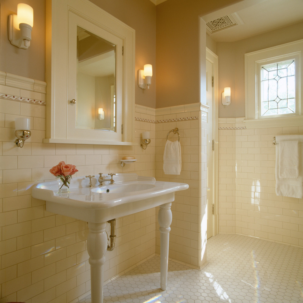 Идея дизайна: главная ванная комната в классическом стиле с консольной раковиной, плиткой кабанчик, желтыми стенами, полом из керамической плитки и бежевой плиткой