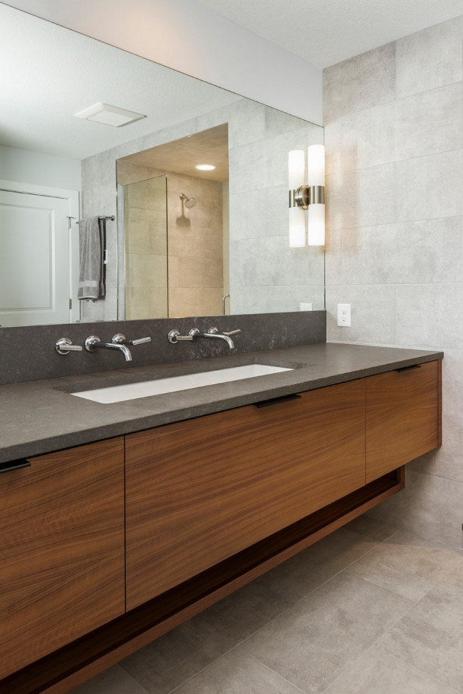 Design ideas for a modern bathroom in Minneapolis with brown cabinets, grey tiles, porcelain tiles, grey walls, porcelain flooring, grey floors, flat-panel cabinets, a submerged sink and grey worktops.