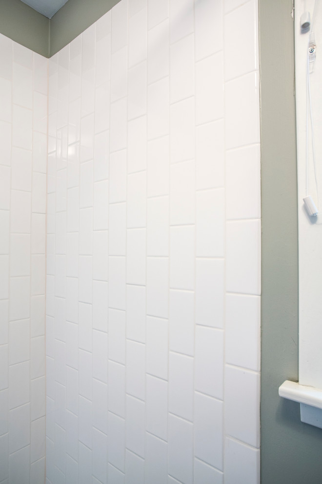 Cette image montre une salle de bain design en bois foncé de taille moyenne avec un carrelage blanc, un carrelage métro, un placard à porte shaker, un mur vert et une cabine de douche avec un rideau.