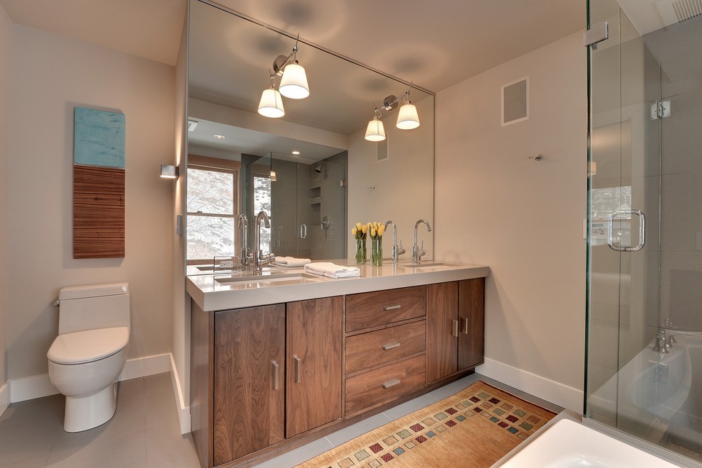 Стильный дизайн: ванная комната в современном стиле с плоскими фасадами, фасадами цвета дерева среднего тона и серой плиткой - последний тренд