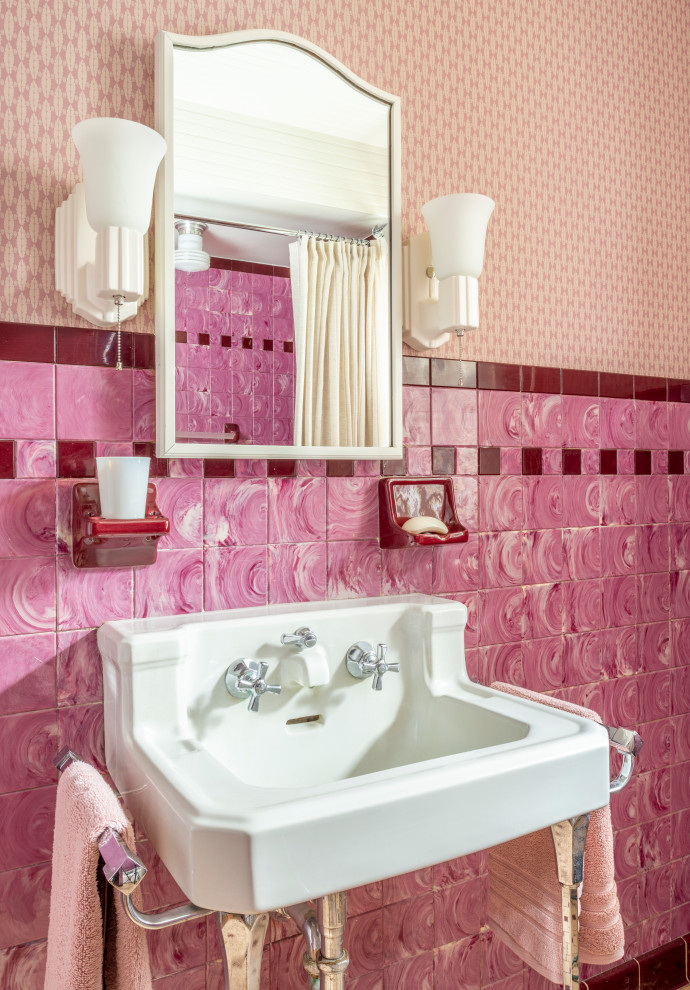 Klassisk inredning av ett badrum, med rosa väggar och ett väggmonterat handfat