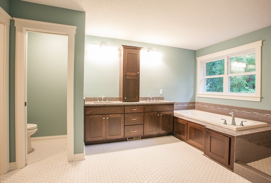 Réalisation d'une salle de bain principale tradition en bois brun de taille moyenne avec un lavabo posé, un plan de toilette en granite, une baignoire posée, une douche d'angle, un carrelage blanc, un mur bleu et un sol en carrelage de céramique.