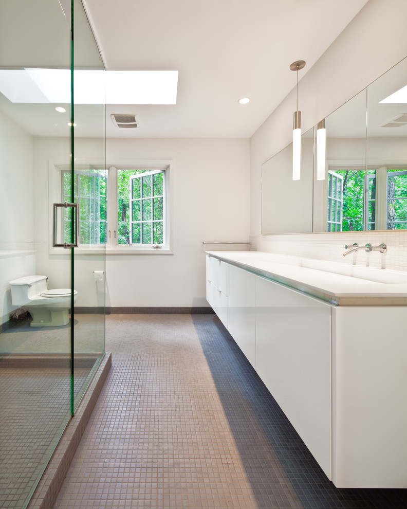 На фото: ванная комната в стиле модернизм с плоскими фасадами, белыми фасадами, угловым душем и серой плиткой
