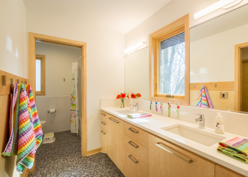 Cette image montre une grande salle de bain design en bois clair pour enfant avec un placard à porte plane, un mur blanc, un sol en carrelage de porcelaine, un lavabo encastré, un plan de toilette en quartz modifié, un sol marron et un plan de toilette blanc.