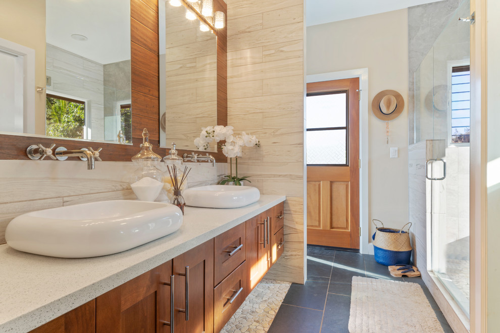 Foto di una stanza da bagno tropicale con ante in stile shaker, ante in legno scuro, piastrelle bianche, pareti beige, lavabo a bacinella, pavimento nero e top bianco