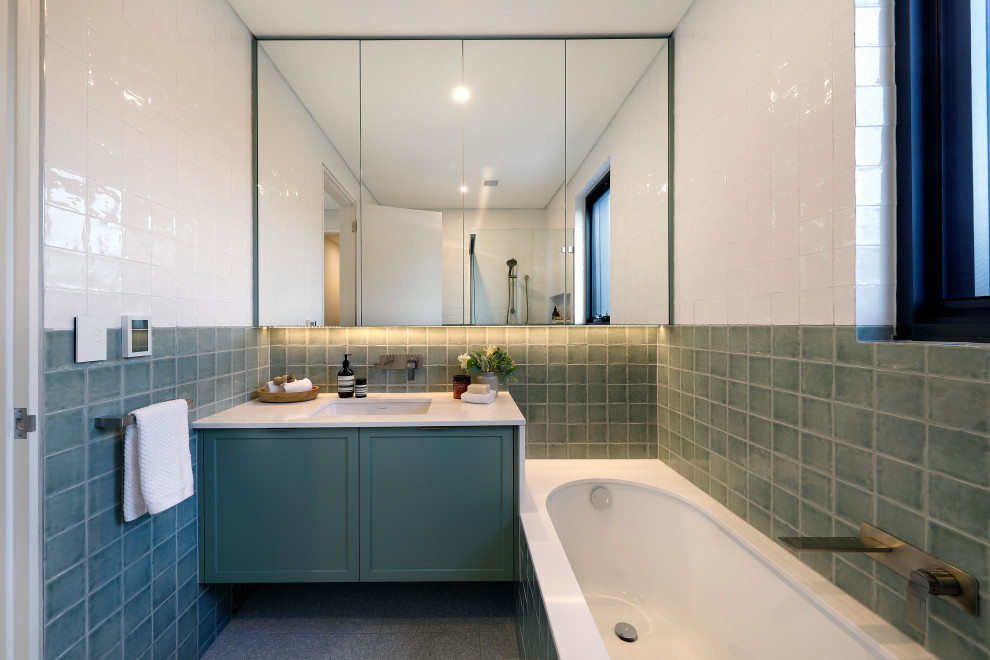 Bild på ett mellanstort funkis vit vitt badrum för barn, med skåp i shakerstil, gröna skåp, ett undermonterat badkar, terrazzogolv, ett undermonterad handfat, bänkskiva i kvarts, grön kakel, en hörndusch och vita väggar