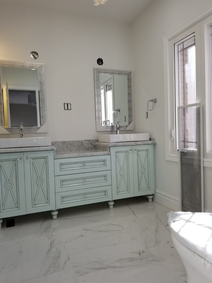 Пример оригинального дизайна: главная ванная комната среднего размера в классическом стиле с фасадами островного типа, зелеными фасадами, душем в нише, унитазом-моноблоком, белой плиткой, плиткой из сланца, белыми стенами, полом из керамогранита, настольной раковиной, мраморной столешницей, белым полом, душем с распашными дверями и серой столешницей