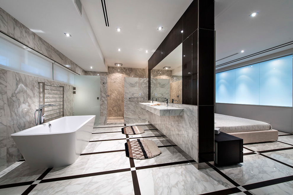 Foto de cuarto de baño principal actual con lavabo suspendido, bañera exenta y piedra