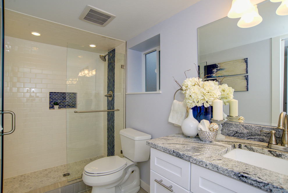 Bild på ett mellanstort funkis vit vitt en-suite badrum, med blå väggar, luckor med infälld panel, vita skåp, en dusch i en alkov, en toalettstol med separat cisternkåpa, vit kakel, keramikplattor, klinkergolv i keramik, ett undermonterad handfat, marmorbänkskiva, grått golv och dusch med gångjärnsdörr