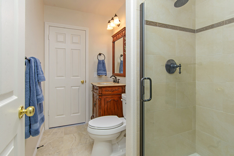 Aménagement d'une salle d'eau montagne de taille moyenne avec un placard en trompe-l'oeil, des portes de placard marrons, une douche d'angle, WC séparés, un carrelage marron, du carrelage en travertin, un mur blanc, un sol en travertin, un plan de toilette en quartz modifié, un sol beige, un lavabo encastré, une cabine de douche à porte battante, un plan de toilette beige, meuble simple vasque et meuble-lavabo sur pied.