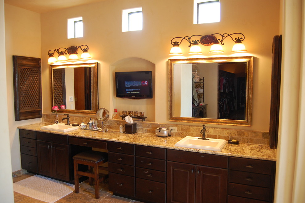 Example of a tuscan master travertine floor bathroom design in Austin with raised-panel cabinets, dark wood cabinets, granite countertops and beige walls