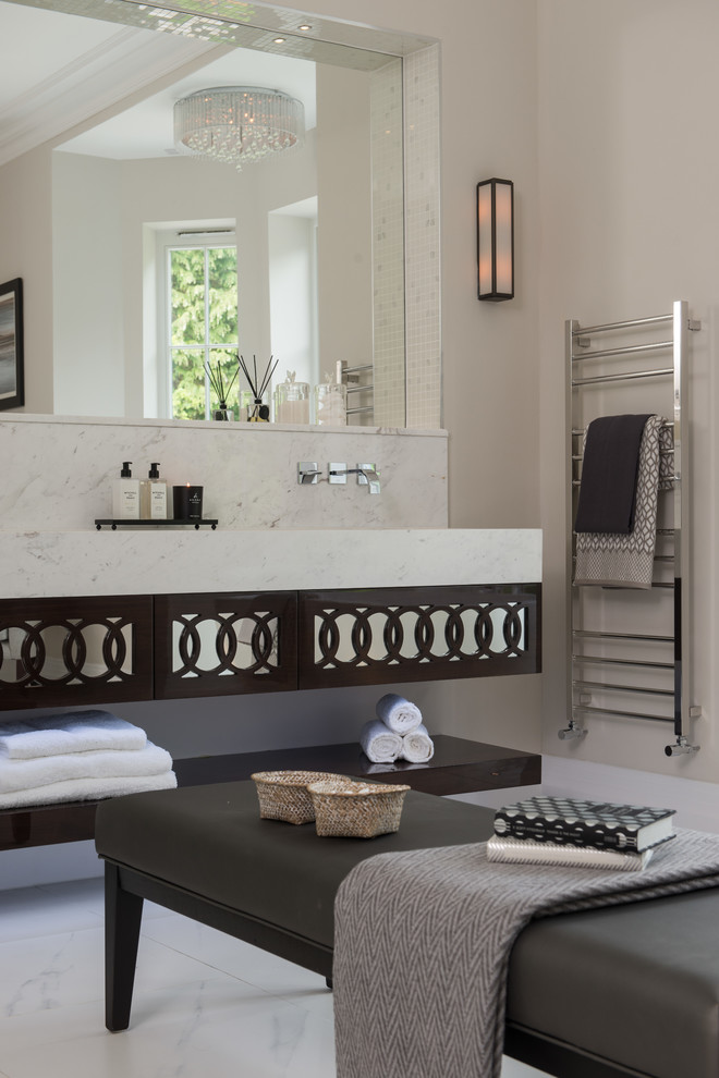 Cette image montre une salle de bain traditionnelle avec un mur beige, un sol en marbre et un lavabo suspendu.