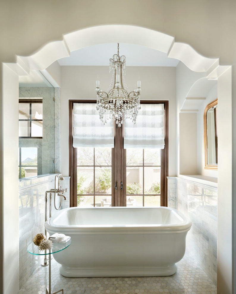 Foto på ett medelhavsstil badrum, med ett fristående badkar, vit kakel, tunnelbanekakel, beige väggar och mosaikgolv