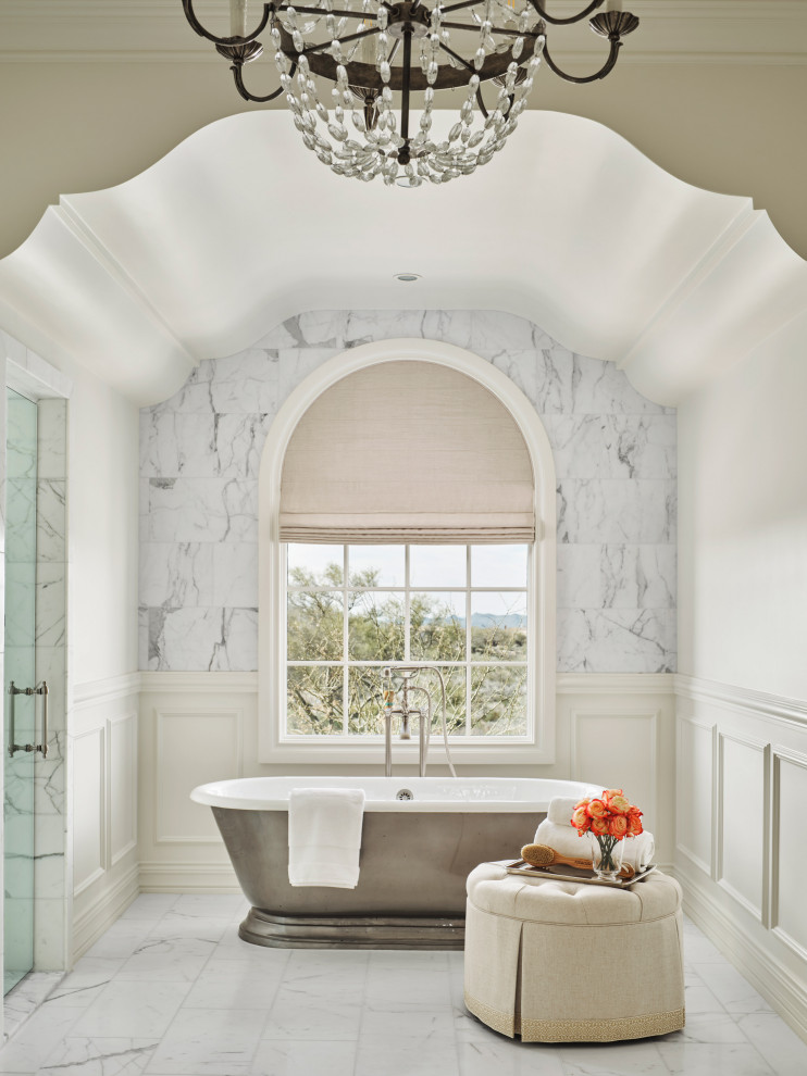 Foto de cuarto de baño mediterráneo con bañera exenta y suelo de mármol