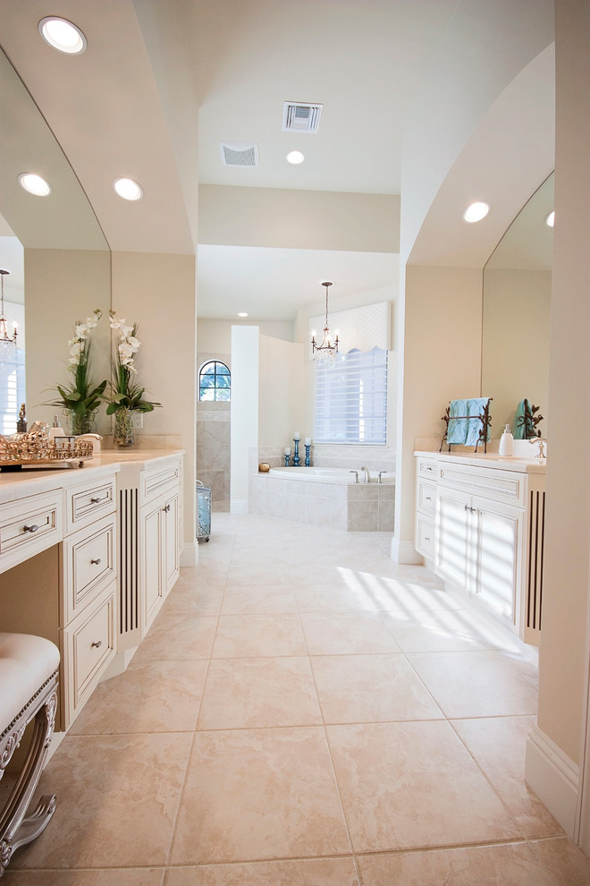 Large traditional ensuite bathroom in Miami with a console sink, marble worktops, a built-in bath, a corner shower, a one-piece toilet, beige tiles, ceramic tiles, white walls and ceramic flooring.
