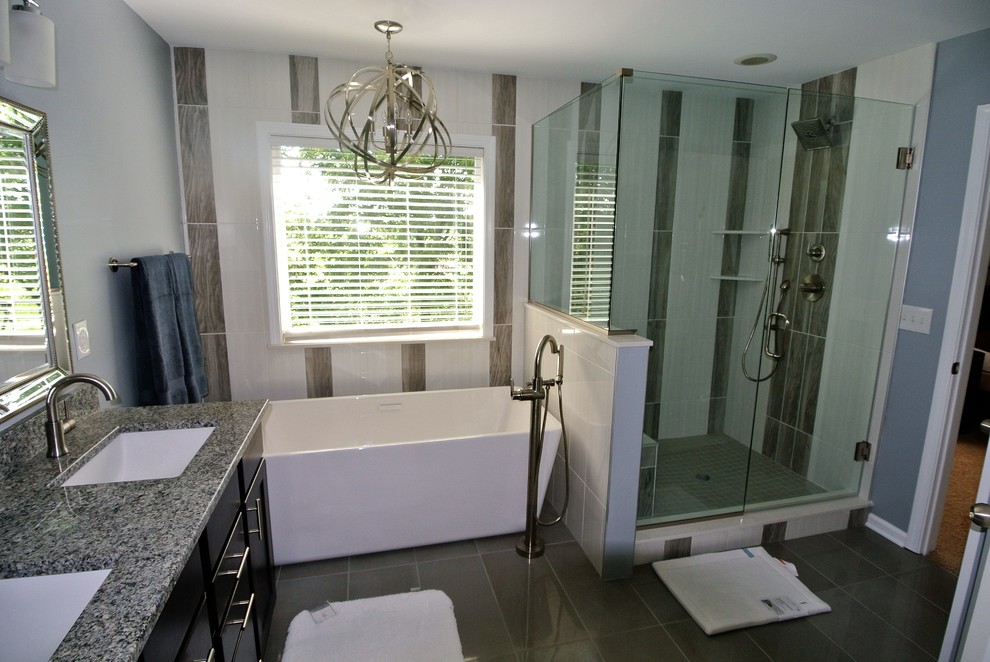 This is an example of a small classic ensuite bathroom in Indianapolis with raised-panel cabinets, dark wood cabinets, a freestanding bath, a double shower, grey tiles, ceramic tiles, green walls, ceramic flooring, a submerged sink and limestone worktops.