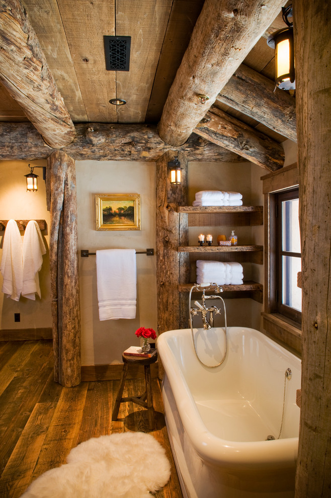 На фото: ванная комната в стиле рустика с отдельно стоящей ванной, коричневыми стенами и темным паркетным полом с