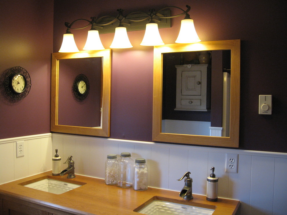 Inspiration pour une salle de bain principale traditionnelle en bois clair de taille moyenne avec un placard en trompe-l'oeil, un mur violet, un lavabo encastré et un plan de toilette en bois.