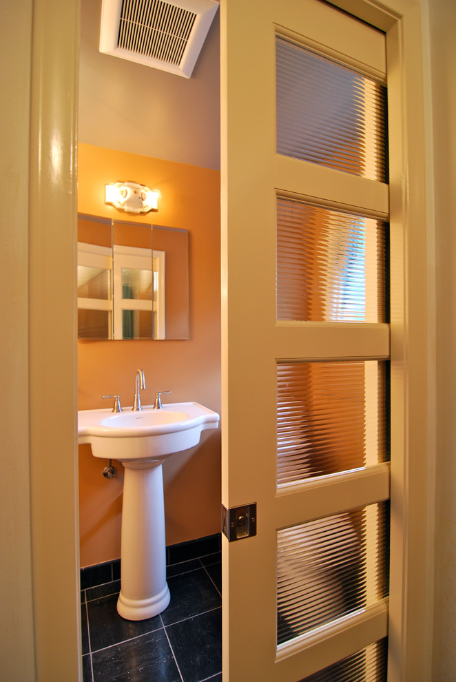 Пример оригинального дизайна: маленькая главная ванная комната в стиле модернизм с раковиной с пьедесталом, черной плиткой, оранжевыми стенами и полом из сланца для на участке и в саду