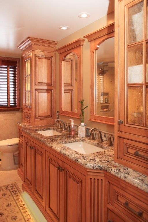 Large country ensuite bathroom in Philadelphia with medium wood cabinets, granite worktops, a submerged sink, beaded cabinets, a one-piece toilet and beige tiles.