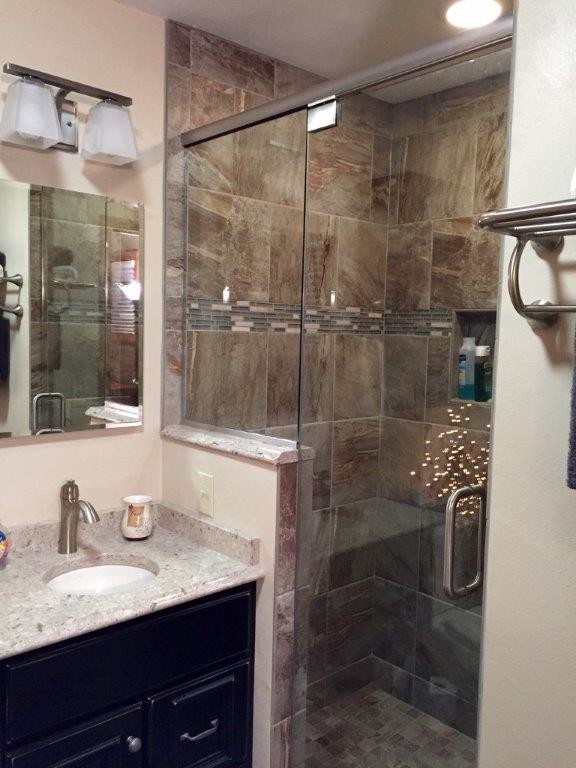 Medium sized traditional shower room bathroom in Milwaukee with raised-panel cabinets, dark wood cabinets, an alcove shower, beige tiles, ceramic tiles, beige walls, a submerged sink and recycled glass worktops.