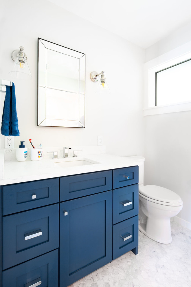 Idée de décoration pour une salle d'eau marine de taille moyenne avec un placard à porte shaker, des portes de placard bleues, WC séparés, un mur blanc, un sol en marbre, un lavabo encastré, un plan de toilette en surface solide, un sol gris et un plan de toilette blanc.