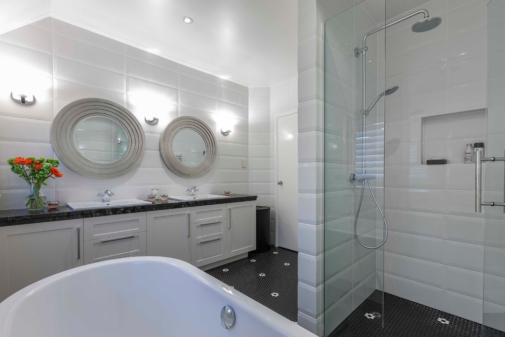 Modernes Badezimmer mit Schrankfronten im Shaker-Stil, weißen Schränken, freistehender Badewanne, Duschnische, schwarzen Fliesen, schwarz-weißen Fliesen, weißen Fliesen, weißer Wandfarbe, Mosaik-Bodenfliesen und Einbauwaschbecken in Auckland