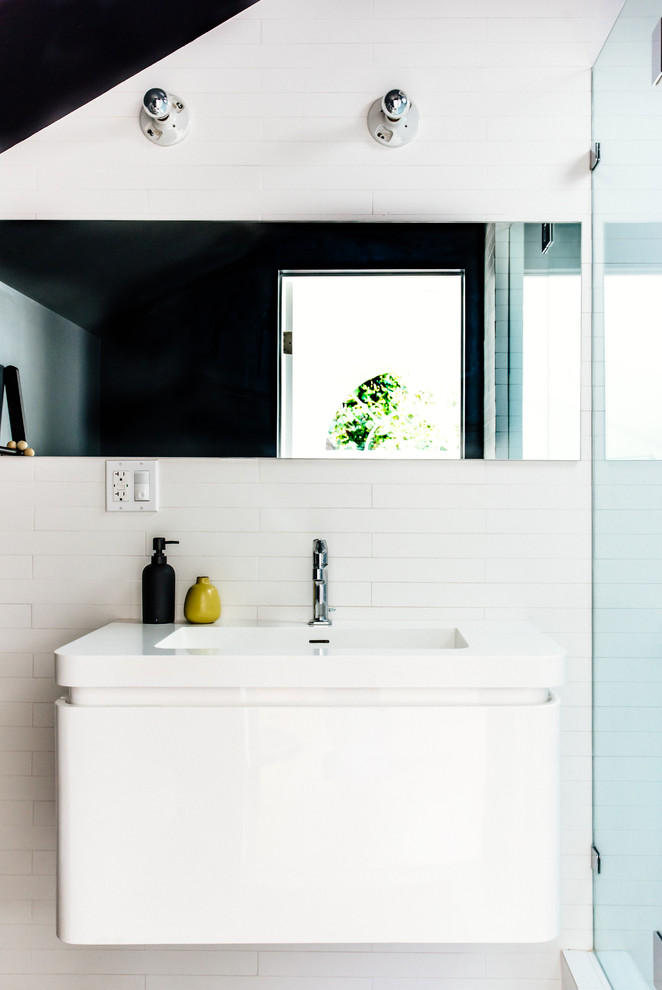 Idée de décoration pour une petite salle d'eau minimaliste avec un placard à porte plane, des portes de placard blanches, un carrelage blanc, un mur gris, un sol en carrelage de céramique, un lavabo posé et un plan de toilette en surface solide.