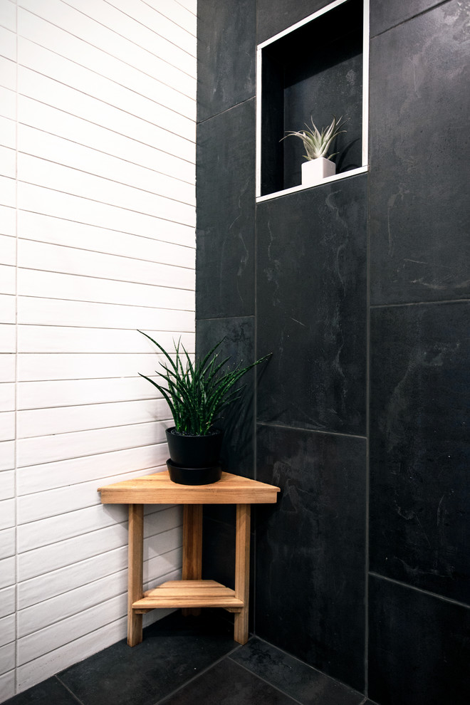 Стильный дизайн: маленькая главная ванная комната в современном стиле с плоскими фасадами, светлыми деревянными фасадами, душем в нише, унитазом-моноблоком, черно-белой плиткой, керамической плиткой, белыми стенами, полом из сланца, подвесной раковиной, столешницей из искусственного камня, черным полом, душем с распашными дверями и белой столешницей для на участке и в саду - последний тренд