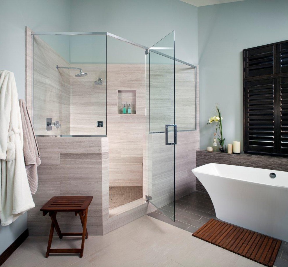 Photo of a large contemporary ensuite half tiled bathroom in San Diego with a freestanding bath, a corner shower, beige tiles, blue walls, ceramic flooring, dark wood cabinets, stone tiles, beige floors, a hinged door, a two-piece toilet, a vessel sink and engineered stone worktops.