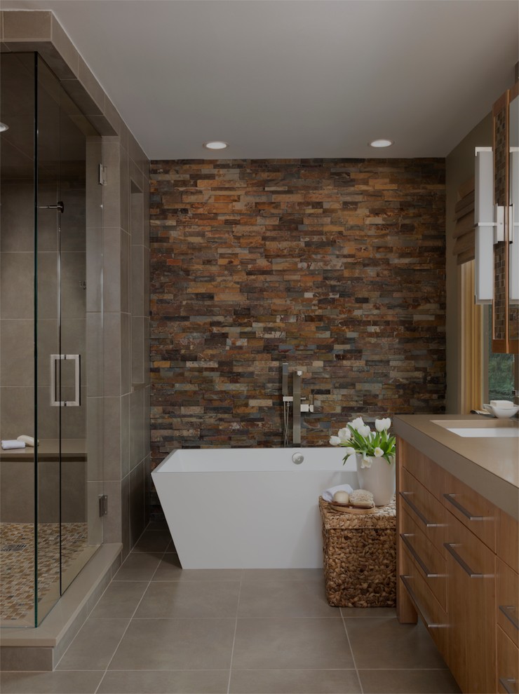 Пример оригинального дизайна: ванная комната в современном стиле с врезной раковиной, плоскими фасадами, фасадами цвета дерева среднего тона, отдельно стоящей ванной, плиткой из сланца и коричневой столешницей