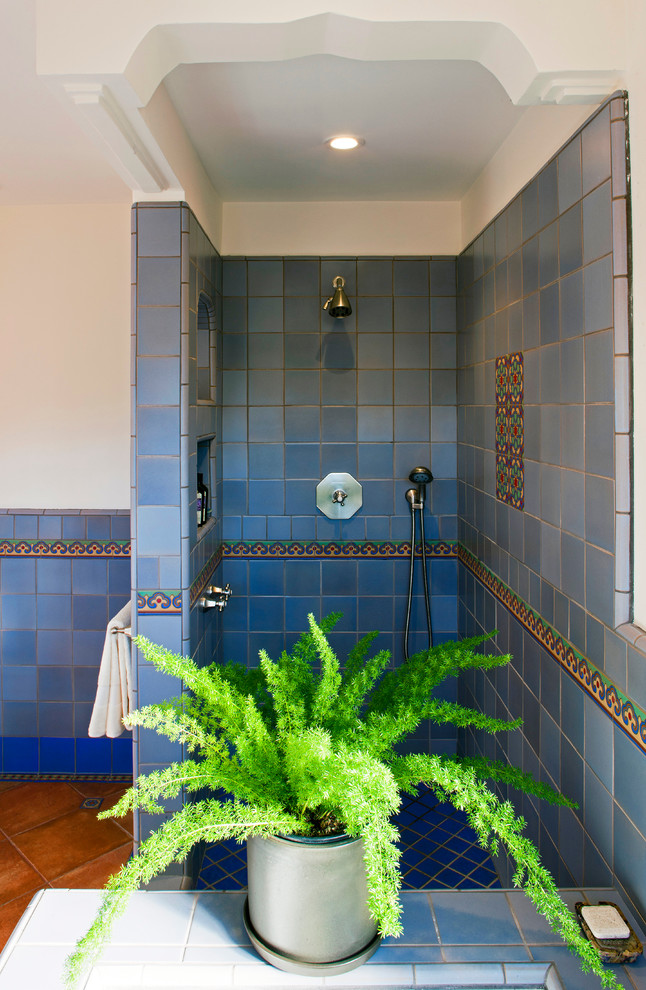 Exemple d'une grande douche en alcôve principale chic en bois foncé avec un placard avec porte à panneau encastré, une baignoire posée, un carrelage bleu, des carreaux de céramique, un mur blanc, tomettes au sol, un lavabo encastré, un plan de toilette en carrelage et WC à poser.