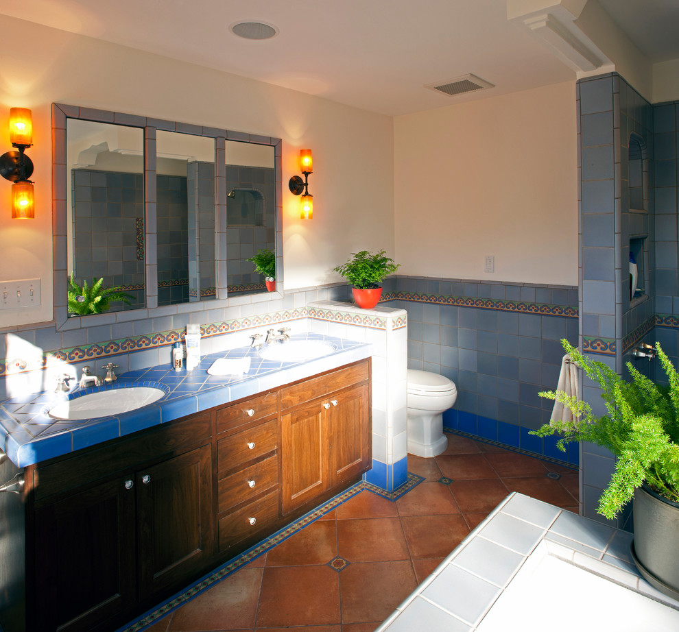 Пример оригинального дизайна: большая главная ванная комната в классическом стиле с фасадами с утопленной филенкой, темными деревянными фасадами, накладной ванной, душем в нише, унитазом-моноблоком, синей плиткой, керамической плиткой, белыми стенами, полом из терракотовой плитки, врезной раковиной и столешницей из плитки