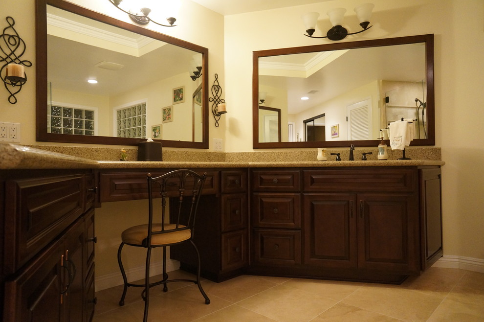 Modelo de cuarto de baño principal clásico renovado grande con armarios con paneles con relieve, puertas de armario de madera en tonos medios, paredes beige, lavabo bajoencimera, encimera de granito y suelo beige